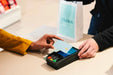 PAX A35 Android PIN pad in use at a retail checkout with a customer making a payment.